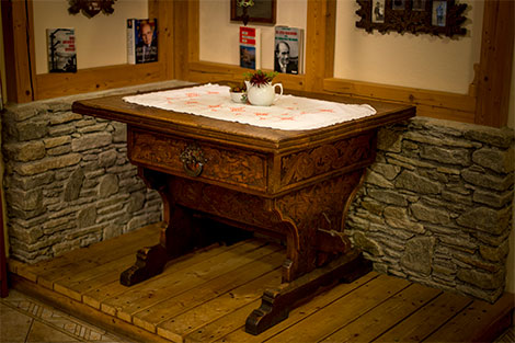 Der Kaisertisch befindet sich im Speisezimmer des Gasthof Orthofer. Der Tisch ist aus dunklem Holz und an der Vorderseite befindet sich eine reich verzierte Lade.