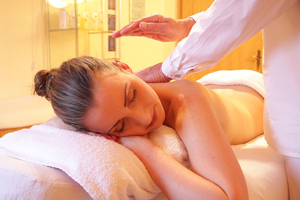 Eine Frau liegt auf einer Liege und bekommt eine Massage.
